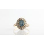 A hallmarked 9ct yellow gold topaz and diamond cluster ring, set with a central oval cut blue topaz,