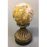 A marble orb on brass base. Height 17cm.