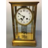 A brass and glass cased mantel clock. Height 30cm.
