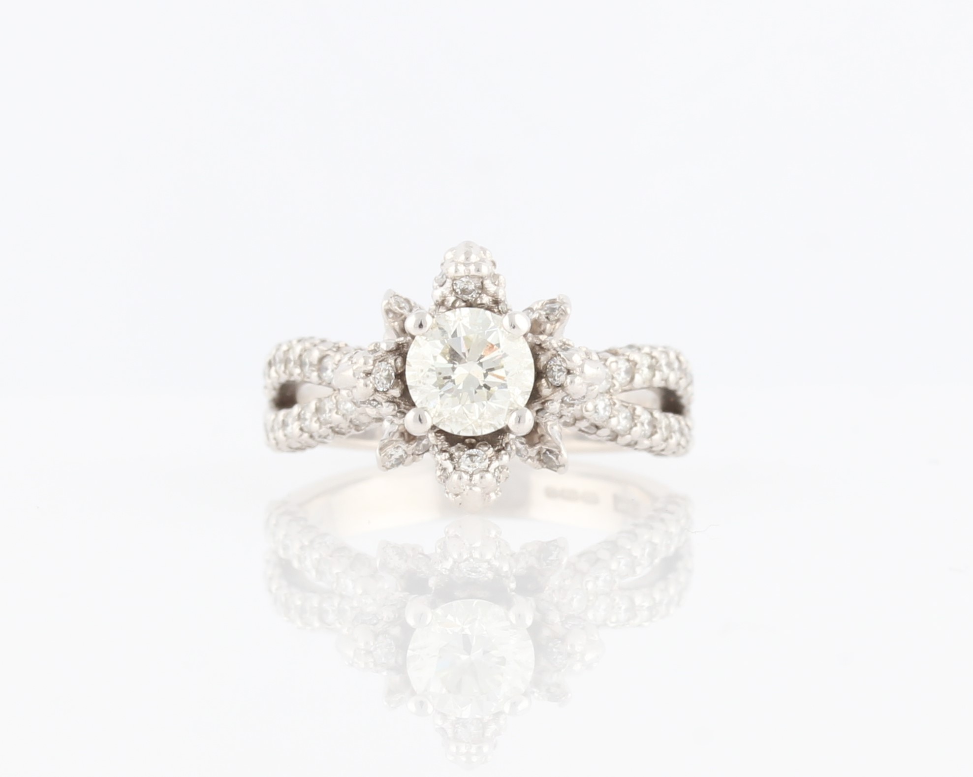 An 18ct white gold diamond ring, of organic design, set centrally with a round brilliant cut