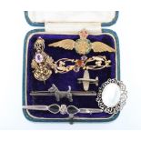 A collection of brooches to include, a pink stone open metalwork brooch, an orange and purple