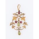 An Edwardian peridot, green glass, seed pearl and garnet pendant, set with round cut garnets, a pear