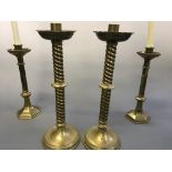 Two pairs of brass altar candlesticks. Heights 33cm and 40cm.