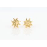 A pair of flower design stud earrings, stamped 750.