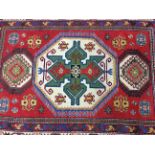 An Afghan style red rug, 212cm x 148cm.