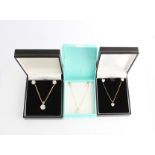 Three part suites of cubic zirconia jewellery, each comprising a pair of earrings and a pendant