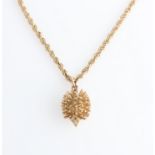 A hallmarked 9ct yellow gold hedgehog pendant, on a fancy curb link chain, stamped 9ct.