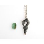 A carved stone pendant depicting a shell suspended on a chain, together with a green piece of