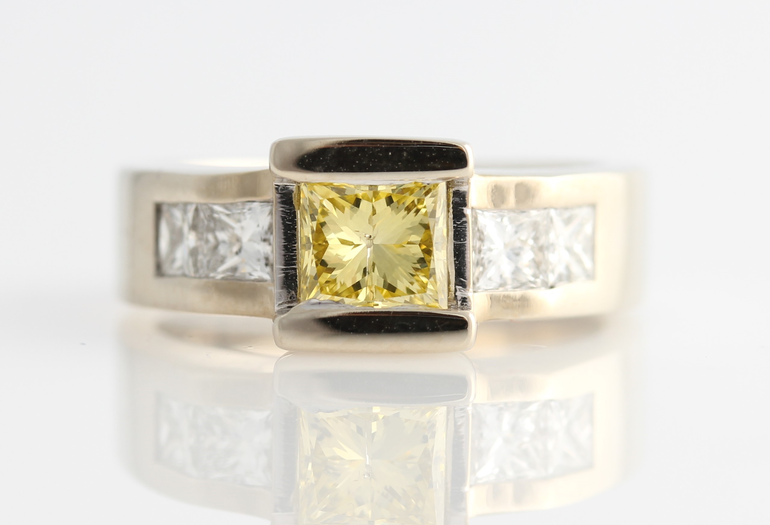 *A diamond ring set with a central princess cut treated (laser drilled) yellow diamond measuring