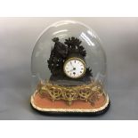 A glass dome clock with gamekeeper design. Height 38cm.