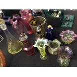 Eleven multi-coloured glass decanters with stoppers and vases.