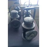 Five assorted black railway lamps.