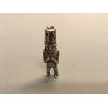 A South American white metal figure with zig zag headdress. Height 9cm.