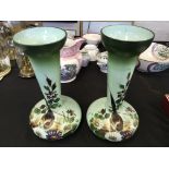 A pair of Victorian green glass vases with hand painted floral and bird design.
