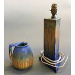 A Ruskin blue and yellow jug, height 14cm and triangular table lamp base, height 35cm.