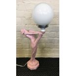 A pink Art Deco style female form light with white globe shade.