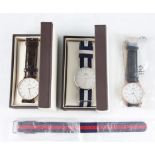 Three Daniel Wellington wrist watches, two being boxed, along with an additional strap.