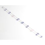 A tanzanite and pink stone bead necklet, set with thirteen oval tanzanite beads and four pink