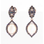 A pair of moonstone, sapphire and diamond drop stud earrings, set with an oval moonstone cabochon,