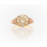 A nine stone diamond cluster ring, set with old mine cut diamonds, with scroll design shoulders,