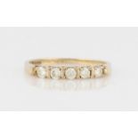 A hallmarked 9ct yellow gold five stone diamond ring, bar set with five round brilliant cut