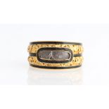 An early 19th Century memorial ring, set with a plaited hair panel covered with glass (A/F), with