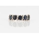 An 18ct white gold sapphire and diamond half eternity ring, set with five oval cut sapphires,