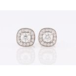 A pair of diamond cluster earrings, each set with a central round brilliant cut diamond, measuring