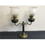 A two branch brass oil lamp with glass shades, height 60cm.