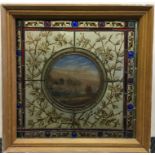 A wood framed stained glass panel depicting lake scene.