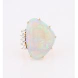 An 18ct yellow gold opal and diamond dress ring, set with a curved triangular opal cabochon,