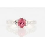 An 18ct white gold pink tourmaline and diamond ring, set with a central oval cut pink tourmaline,