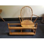 An Ercol elm rocking chair with a wall mounted plate rack.