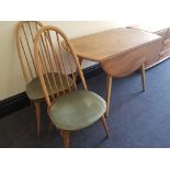 An Ercol elm drop leaf table together with four stick back dining chairs.