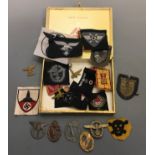A cigar box containing a collection of various Nazi German patches, badges etc.