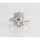 An Art Deco diamond ring, set with a central round brilliant cut diamond, measuring approx. 0.