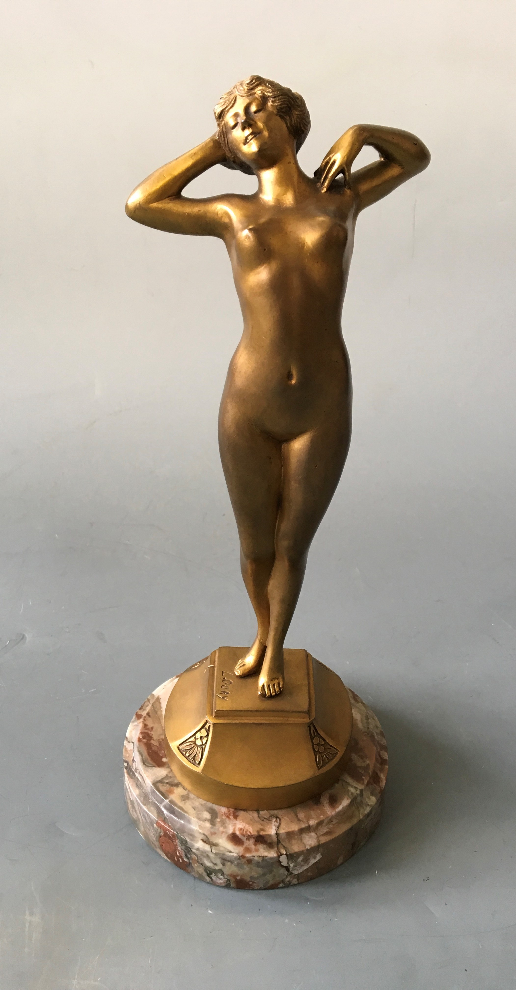 L. OURY. A signed gilt bronze Art Deco nude female figurine titled ‘Premier Trisson’, on marble