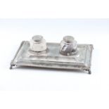 An early 20th Century silver inkwell stand with two inkwells, the stand of rectangular form and