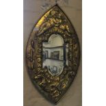 A brass beaten mirror decorated with cherubs and sea creatures.
