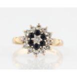 A 9ct yellow gold sapphire and diamond tiered cluster ring, claw set with a central round