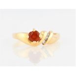 An orange stone and diamond ring, set with a round cut orange stone, with band channel set with
