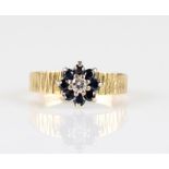 A hallmarked 18ct yellow gold sapphire and diamond cluster ring, set with a central round