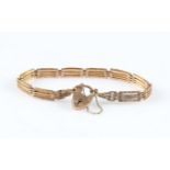A gate bracelet, each link engraved with repeat design, bracelet stamped 9, with heart padlock