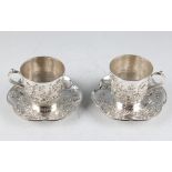 A pair of late 19th/early 20th Century Chinese export silver teacups and saucers, with applied