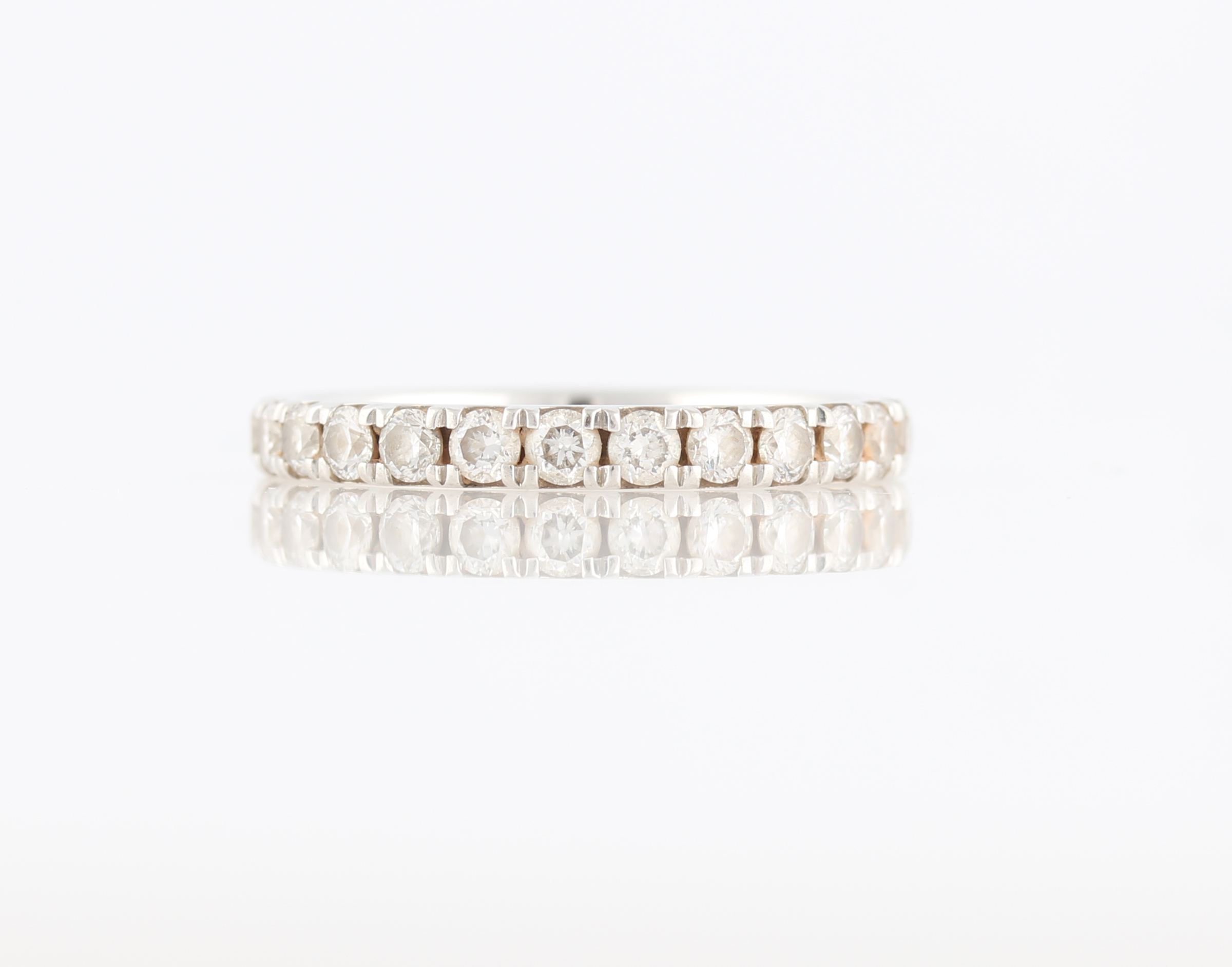 A platinum diamond half eternity ring, set with 13 round brilliant cut diamonds, total diamond