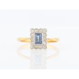 A sapphire and diamond square cluster ring, set with a rectangular cut sapphire, measuring approx.