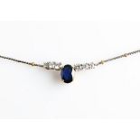 A hallmarked 18ct yellow and white gold sapphire and diamond necklet, set with a central oval cut