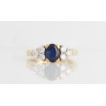 A hallmarked 18ct yellow gold sapphire and diamond ring, set with a central oval cut sapphire,
