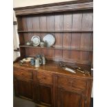 An oak English style kitchen dresser fitted with four cupboards to base and three drawers with plate