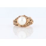 A hallmarked 9ct yellow gold pearl set ring, with open metalwork floral and foliage shoulders and